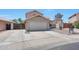 Wide shot of a beige two-story home, 2 car garage, neutral desert landscaping with secure gate at 13676 N 73Rd Dr, Peoria, AZ 85381