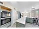 Modern kitchen boasts stainless steel appliances, a large island with seating, and sleek countertops at 13676 N 73Rd Dr, Peoria, AZ 85381