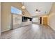 Open-concept living room featuring wood floors, high vaulted ceiling, large windows, and built-in shelves at 13676 N 73Rd Dr, Peoria, AZ 85381