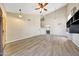 Large living room with wood flooring, vaulted ceilings, updated fan and built in wall shelves at 13676 N 73Rd Dr, Peoria, AZ 85381
