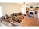 Bright living room features hardwood floors, couches and entertainment center with ceiling fan at 15831 W Marconi Ave, Surprise, AZ 85374