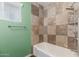 Bathroom shower with stone tiling, updated fixtures and a window at 2938 N 18Th Ave, Phoenix, AZ 85015