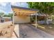 Spacious covered carport providing ample parking with a view of the adjacent mature landscaping and house at 2938 N 18Th Ave, Phoenix, AZ 85015