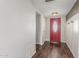 Inviting entryway featuring a striking red front door, dark laminate flooring, and convenient coat hooks at 2938 N 18Th Ave, Phoenix, AZ 85015