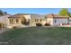 Expansive backyard with a covered patio, lush green lawn, and desert landscaping at 21315 E Marsh Rd, Queen Creek, AZ 85142