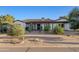Inviting single story home with desert landscaping, blooming trees, and a paver driveway at 21315 E Marsh Rd, Queen Creek, AZ 85142