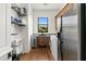 Functional laundry room featuring wooden cabinets, stainless steel appliances, and shelving at 21315 E Marsh Rd, Queen Creek, AZ 85142