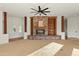Carpeted living room with stone fireplace, built-in bookshelves, and bright natural light at 21315 E Marsh Rd, Queen Creek, AZ 85142