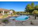Refreshing backyard pool with a rock surround, desert plants, and a covered patio in the background at 21315 E Marsh Rd, Queen Creek, AZ 85142