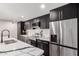 Modern kitchen features granite countertops, stainless steel appliances and black cabinets at 3008 W Michigan Ave, Phoenix, AZ 85053