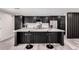 Contemporary kitchen with dark cabinets, quartz countertops, island with bar seating, and stainless appliances at 3008 W Michigan Ave, Phoenix, AZ 85053