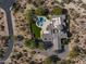 Majestic estate featuring a sparkling pool, lush landscaping, and luxurious outdoor living spaces at 10160 E Whispering Wind Dr, Scottsdale, AZ 85255
