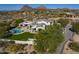 Breathtaking aerial view of the property featuring the pool, patio, green backyard, and views of the surrounding area at 10160 E Whispering Wind Dr, Scottsdale, AZ 85255