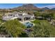 Gorgeous estate with a sparkling pool, beautiful landscaping, and stunning mountain backdrop at 10160 E Whispering Wind Dr, Scottsdale, AZ 85255