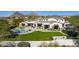 Stunning home featuring a lush lawn, pool, mountain views and a covered patio area perfect for entertaining at 10160 E Whispering Wind Dr, Scottsdale, AZ 85255