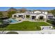 Beautiful home with a sparkling pool, manicured lawn, and scenic mountain views at 10160 E Whispering Wind Dr, Scottsdale, AZ 85255
