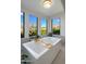 Modern bathroom features a luxurious soaking tub with large windows offering scenic views of the outdoor landscape at 10160 E Whispering Wind Dr, Scottsdale, AZ 85255