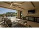 Inviting covered patio with comfortable seating, ceiling fan, and stunning views of the pool at 10160 E Whispering Wind Dr, Scottsdale, AZ 85255
