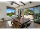 Bright dining area with modern light fixture, backyard views, and access to outdoor pool at 10160 E Whispering Wind Dr, Scottsdale, AZ 85255