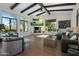 Comfortable living room showcasing a stone fireplace, hardwood floors, beamed ceilings and great backyard views at 10160 E Whispering Wind Dr, Scottsdale, AZ 85255