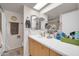Bathroom features an extended vanity with mirror and updated fixtures at 10438 W Butler Dr, Peoria, AZ 85345