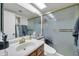 Bathroom features a shower with glass doors, a vanity, and ample lighting at 10438 W Butler Dr, Peoria, AZ 85345