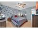 Spacious bedroom features stylish accent wall, ceiling fan, and tiled floors at 10438 W Butler Dr, Peoria, AZ 85345