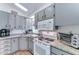 Compact kitchen with updated cabinets, white appliances, and a skylight providing a bright and efficient cooking area at 111 S Greenfield Rd # 400, Mesa, AZ 85206