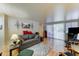 Bright living room featuring wood-look floors, a gray sofa with red pillows, and sliding glass doors for natural light at 111 S Greenfield Rd # 400, Mesa, AZ 85206