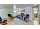 Charming living space with wood-look floors, a comfortable gray sofa, and a view of the front door and kitchen at 111 S Greenfield Rd # 400, Mesa, AZ 85206