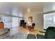Cozy living area offering wood-look floors, comfortable chairs, a television, and easy access to the laundry room at 111 S Greenfield Rd # 400, Mesa, AZ 85206
