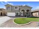 Two-story home with stucco exterior, stone accents, arched entryway, and manicured front yard at 11225 E Sylvan Ave, Mesa, AZ 85212