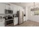 Modern kitchen featuring stainless steel appliances, white cabinetry, and ample counter space, with wood grain flooring at 11979 W Pierce St, Avondale, AZ 85323