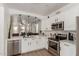 Bright, white kitchen with quartz countertops, stainless steel appliances, and an open view to the living area at 11979 W Pierce St, Avondale, AZ 85323