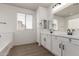 Bright main bathroom with double sinks, a large mirror, and a soaking tub at 11979 W Pierce St, Avondale, AZ 85323