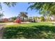 Community playground with green grass and mature shade trees at 11979 W Pierce St, Avondale, AZ 85323