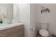 Charming powder room featuring a modern vanity, round mirror and neutral tones at 11979 W Pierce St, Avondale, AZ 85323