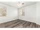 Neutral bedroom with gray wood-look flooring, a ceiling fan and two windows at 12911 W Campbell Ave, Litchfield Park, AZ 85340