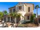 Two-story stucco home showcasing lush landscaping, a tile roof, and a gated driveway at 12911 W Campbell Ave, Litchfield Park, AZ 85340