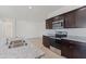 The bright kitchen features an island, stainless appliances, dark cabinets, granite countertops, and tile flooring at 1314 W Kennedy Ave, Coolidge, AZ 85128