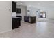 Open-concept kitchen with an island, granite countertops, dark cabinets, stainless appliances, and tile floors at 1314 W Kennedy Ave, Coolidge, AZ 85128