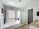 Bright bathroom with a tub, glass-enclosed shower, and tiled flooring at 1350 E Racine Dr, Casa Grande, AZ 85122