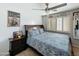 Cozy bedroom with a classic wooden bed frame, ceiling fan, and natural light from shuttered window at 1350 E Racine Dr, Casa Grande, AZ 85122
