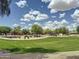 Community park featuring green lawns, walking paths, playground, ramada, and mature trees for recreation at 1350 E Racine Dr, Casa Grande, AZ 85122