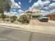 Attractive home featuring a stone turret, a green garage door, desert landscaping, and a brick paver driveway at 1350 E Racine Dr, Casa Grande, AZ 85122