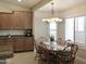Cozy dining area with wood table, seating for six, decorative chandelier, and natural light at 1421 W Rylie Ct, Queen Creek, AZ 85144