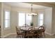 Cozy dining area with wood table, seating for six, decorative chandelier, and natural light at 1421 W Rylie Ct, Queen Creek, AZ 85144