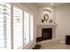 Fireplace with light tile, white shutters on windows, and plants in an alcove at 1421 W Rylie Ct, Queen Creek, AZ 85144