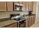 Modern kitchen featuring stainless steel Bosch appliances and wood cabinets at 1421 W Rylie Ct, Queen Creek, AZ 85144
