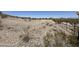Expansive plot of land surrounded by desert vegetation and partial fencing, providing ample space and privacy at 1421 W Rylie Ct, Queen Creek, AZ 85144